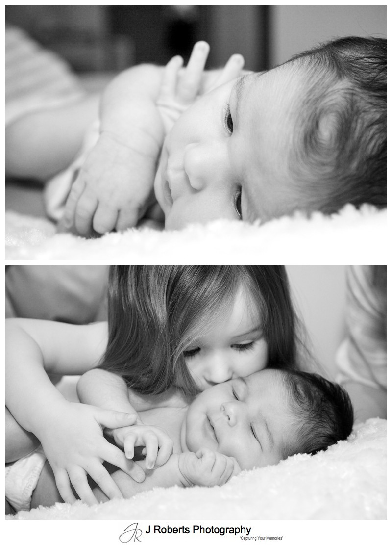 B&W portraits of newborn baby with her big sister kissing her - newborn portrait photography sydney