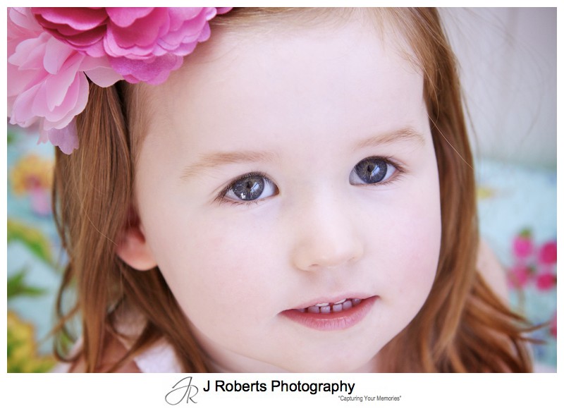 Portrait of a little girl with pink flowers in her hair - family portrait photography sydney