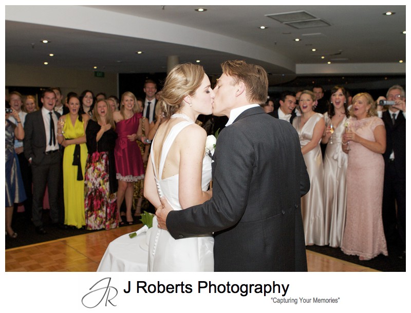 Bride and groom kissing cutting their cake - wedding photography sydney