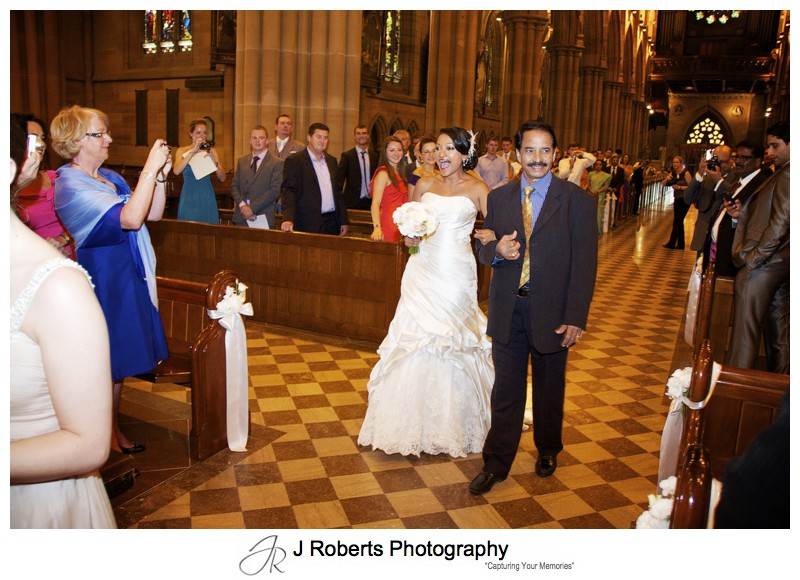 Bride excitedly walking down the aisle at St Mary's Cathedral - wedding photography sydney