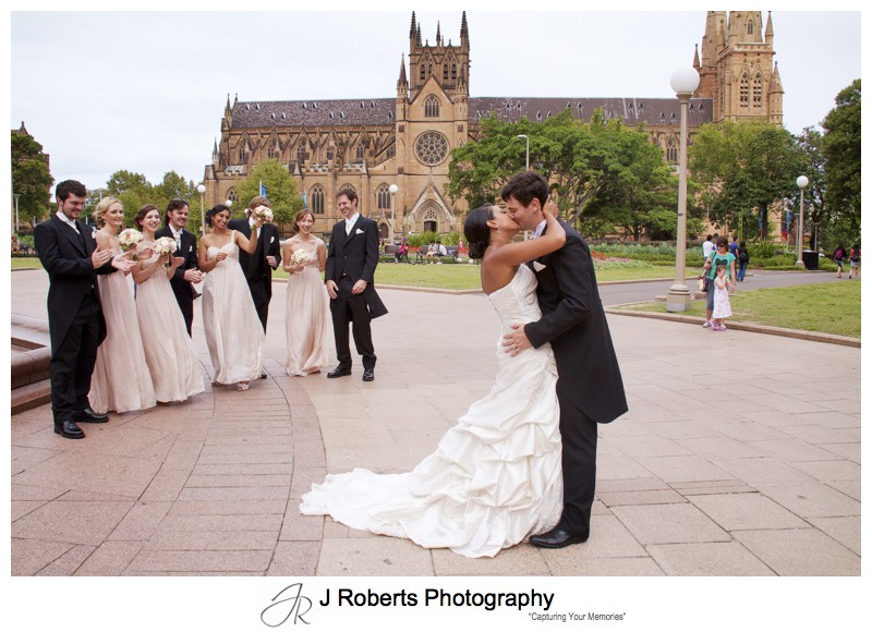 Couple kissing with bridal party in front of St Mary's Cathedral Sydney - wedding photography sydney