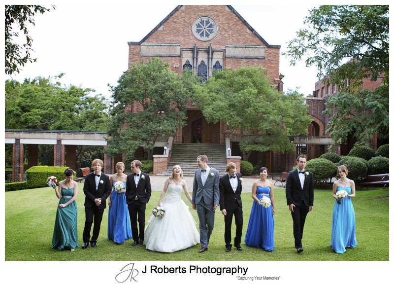 Bridal party walking on the lawns at the front of Pymble Ladies College Chapel - wedding photography sydney