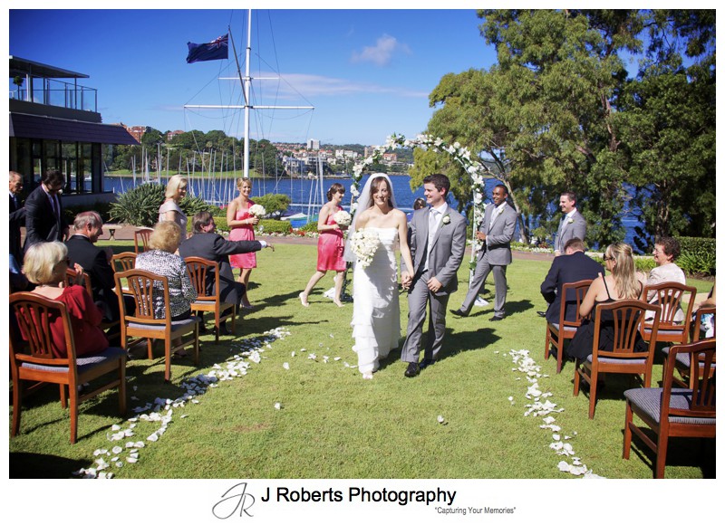 Bride and groom leaving as Mr & Mrs on the RSYS lawns - wedding photography sydney